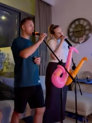 Two guests singing with inflatable saxophones